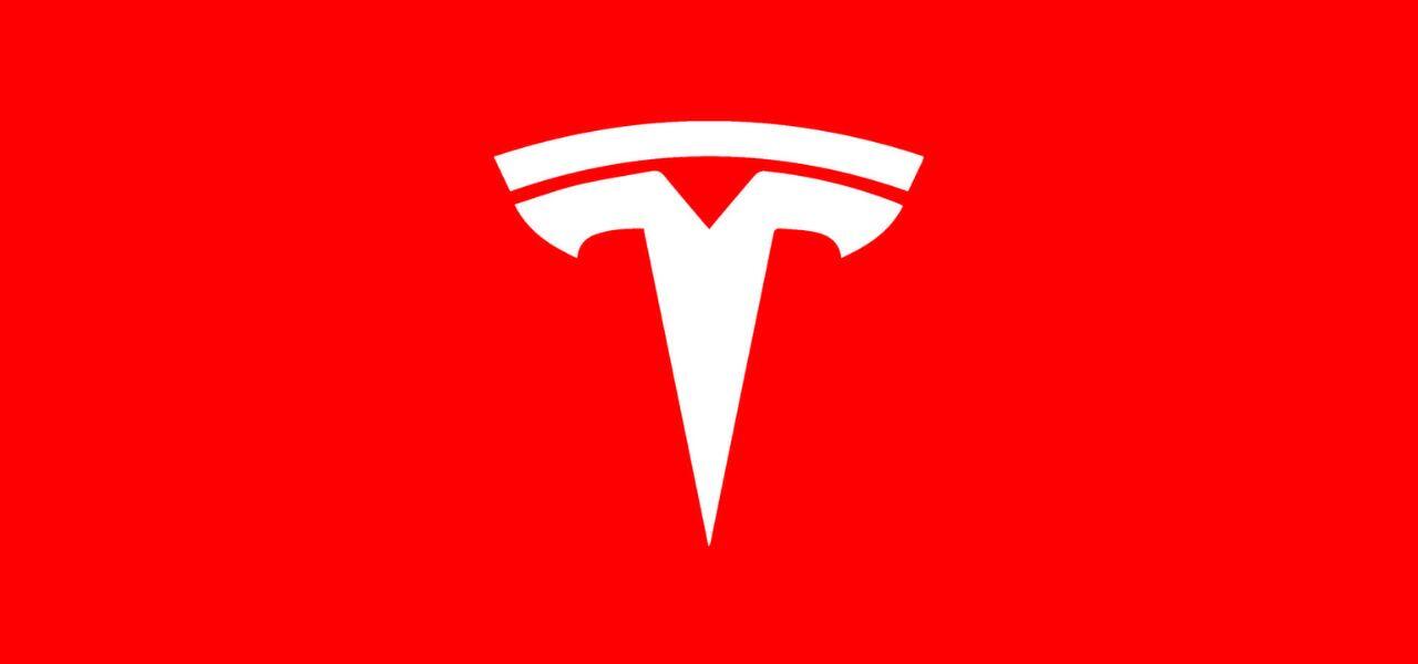 The image shows the Tesla logo, a stylized white letter "T" on a bright red background.