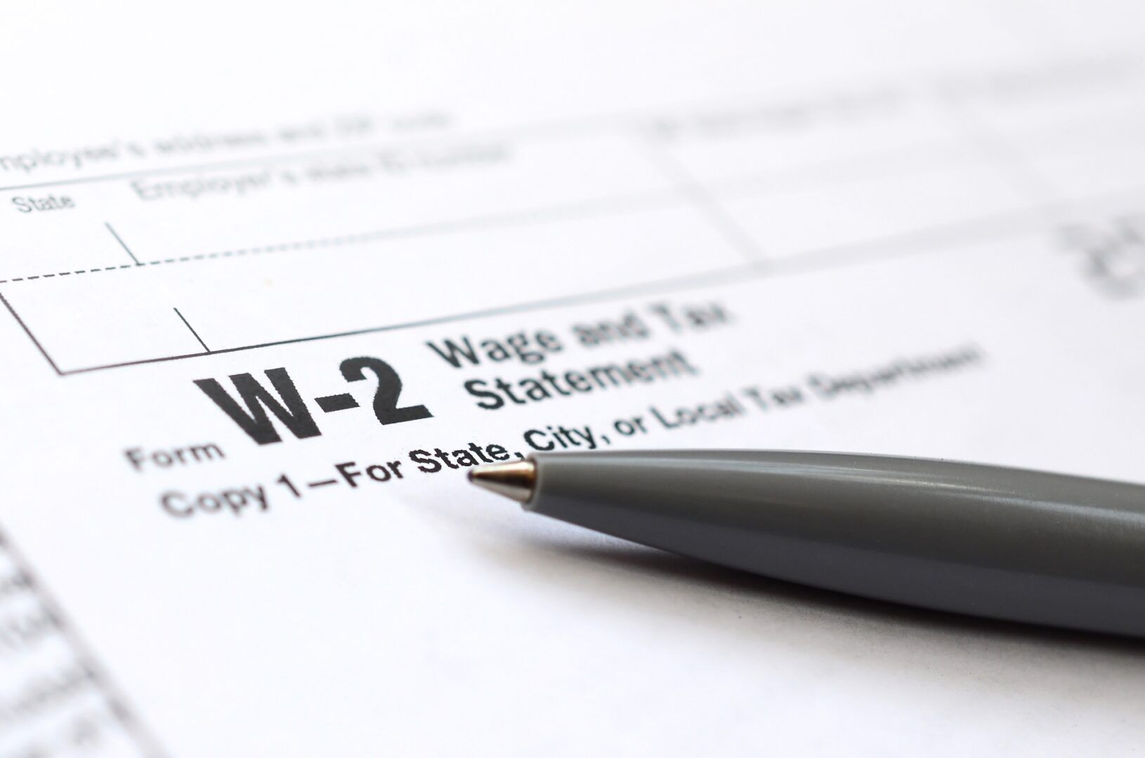 A close-up of a W-2 Wage and Tax Statement form with a gray pen resting on it, highlighting “Form W-2 Wage and Tax Statement”—a key document related to W-2 workers rights every employee should know.