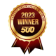 A gold and red ribbon badge reads "2023 Winner" and "500" in bold letters, surrounded by the text "Entrepreneur Franchise 500" around the outer edge. A gold and red ribbon badge reads "2023 Winner" and "500" in bold letters, surrounded by the text "Entrepreneur Franchise 500" around the outer edge.