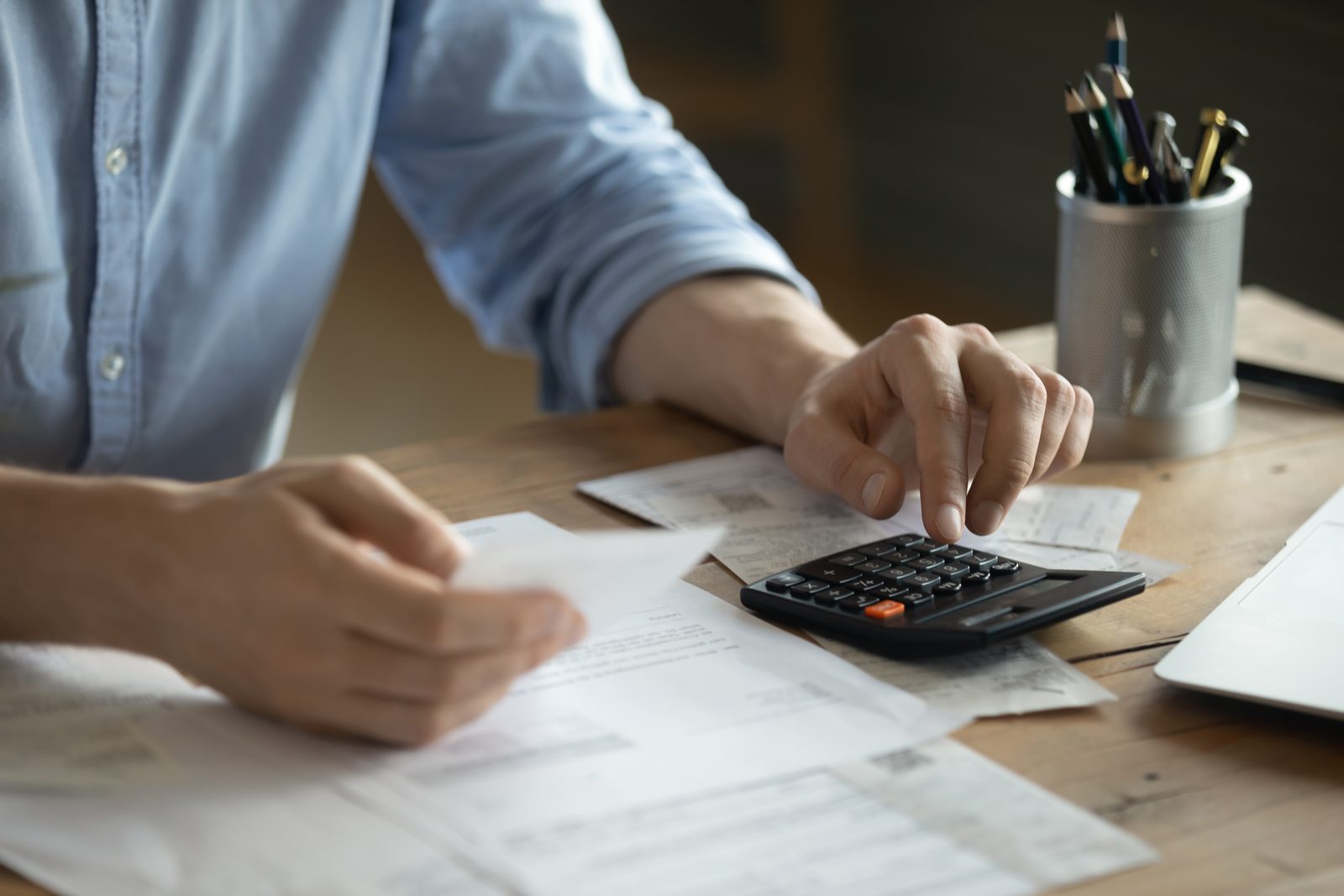 Person using a calculator with financial paperwork on a desk