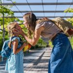Mother showing affection to her young daughter outdoors