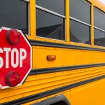 Yellow school bus with its red stop sign extended