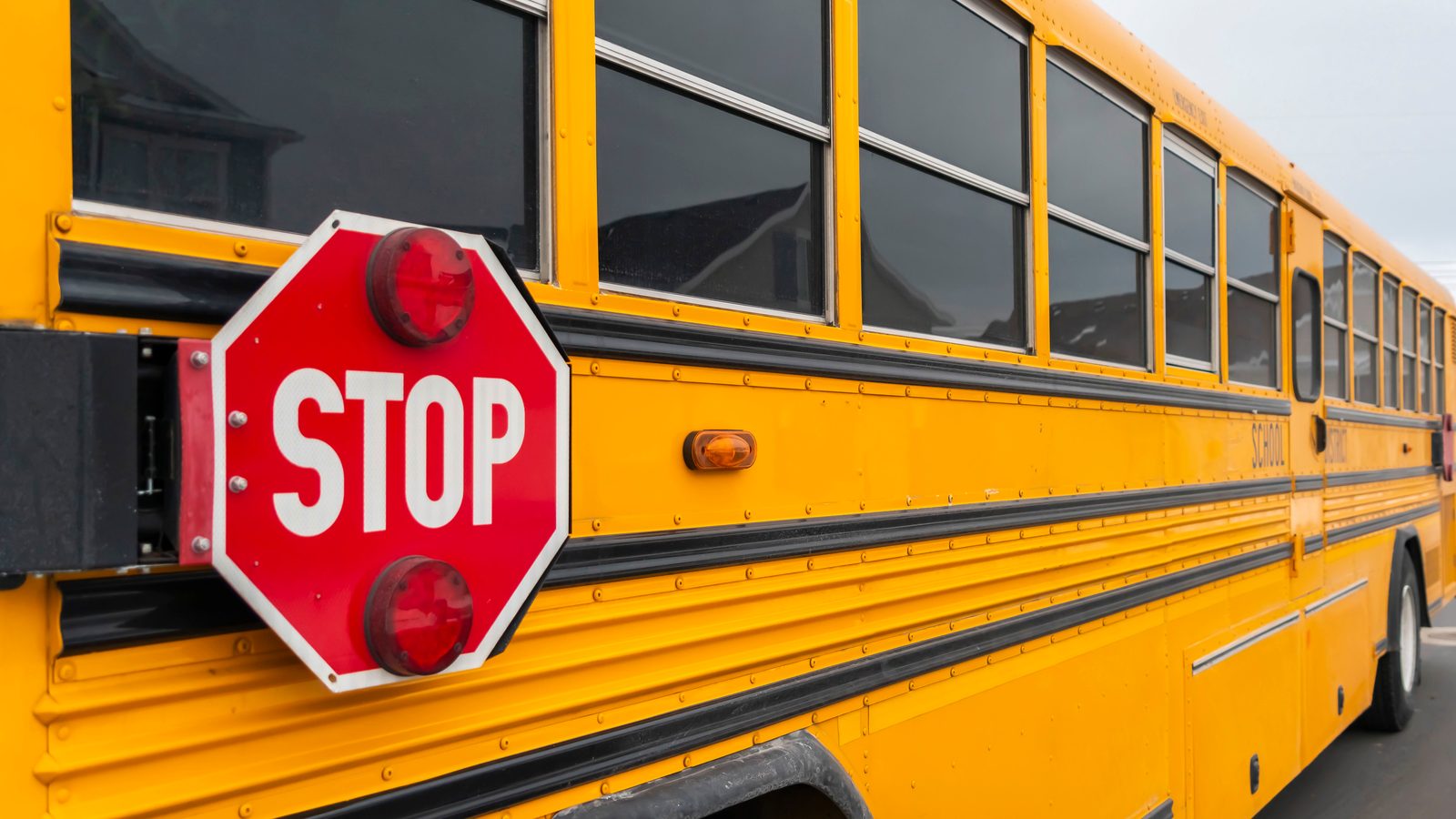 Yellow school bus with its red stop sign extended