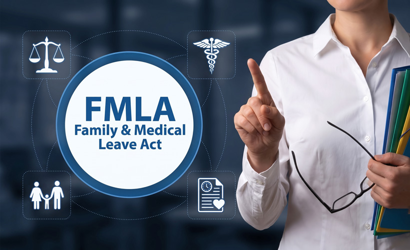 A person points to a digital display reading “FMLA Family & Medical Leave Act,” surrounded by related icons, while holding files and glasses.