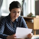 State employee reviewing a job offer letter at her desk