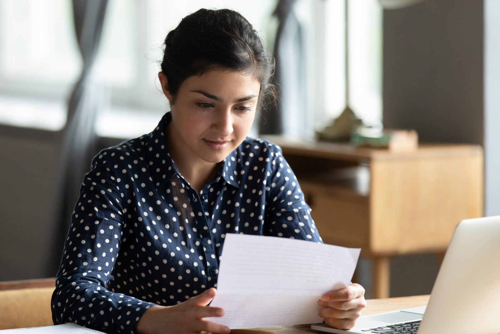 State employee reviewing a job offer letter at her desk